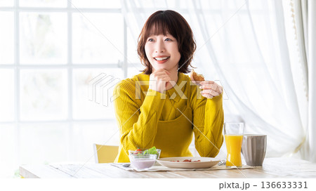 食事をする女性 食事をする女性 136633331