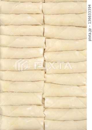Row of frozen spring rolls with frost Row of frozen spring rolls with frost 136633394