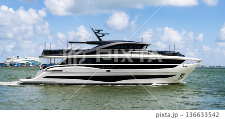 Luxury yacht heading out to sea from marina. Boating and yachting tourism. Luxurious lifestyle. Vacations on summer. Yacht at sea. Sea vacation on summer. Luxury boat motor yacht in marina 136633542