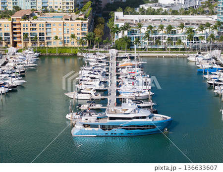 Aerial view of luxury yachts docked at marina. Top-down drone shot of yachts. Boats and sailboats line the scenic seashore. 136633607
