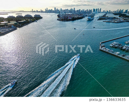 Aerial view of boats on turquoise waters in Miami. Yacht retreat in Miami. Cityscape with sailing vessels in Miami. Aerial view of boats on turquoise waters in Miami. Yacht retreat in Miami. Cityscape with sailing vessels in Miami. 136633635