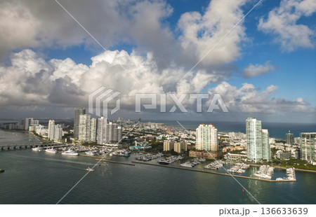 Marina Bay filled with vessels and yacht in Miami. Summer vacation scene with yachts by the oceanfront. Skyline with yachts in Miami. Florida coastline from above with boats. Boat trip in the Miami. Marina Bay filled with vessels and yacht in Miami. Summer vacation scene with yachts by the oceanfront. Skyline with yachts in Miami. Florida coastline from above with boats. Boat trip in the Miami. 136633639