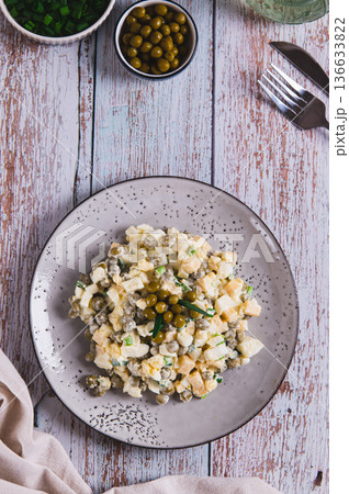 Savory salad with eggs, cheese, peas and chives on a plate on the table top and vertical view 136633822