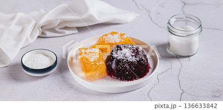 Sweet fruit jelly in coconut flakes on a plate on the table web banner Sweet fruit jelly in coconut flakes on a plate on the table web banner 136633842