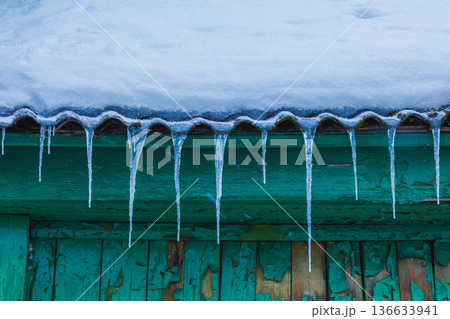 Icicles on the roof of the house. Danger of falling Icicles on the roof of the house. Danger of falling 136633941