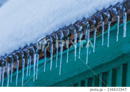Icicles on the roof of the house. Danger of falling Icicles on the roof of the house. Danger of falling 136633947
