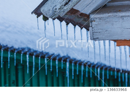Icicles on the roof of the house. Danger of falling Icicles on the roof of the house. Danger of falling 136633968