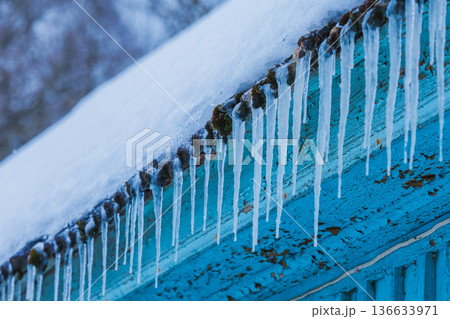 Icicles on the roof of the house. Danger of falling 136633971