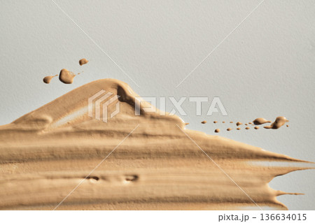 Beige liquid foundation cosmetic swatch showing creamy texture on light background Beige liquid foundation cosmetic swatch showing creamy texture on light background 136634015