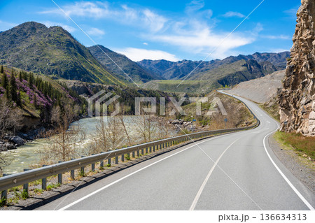 Road stretching along the Chuya River on Chuysky Trakt in Altai Russia. Scenic mountain route through wild Siberian landscape. Road stretching along the Chuya River on Chuysky Trakt in Altai Russia. Scenic mountain route through wild Siberian landscape. 136634313