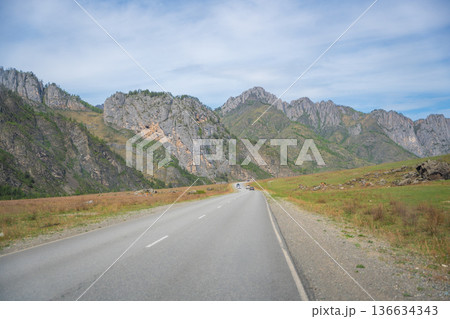 Mountain road running along the Katun river in Altai Russia. Scenic route winding through natural landscapes of the Altai mountains. 136634343