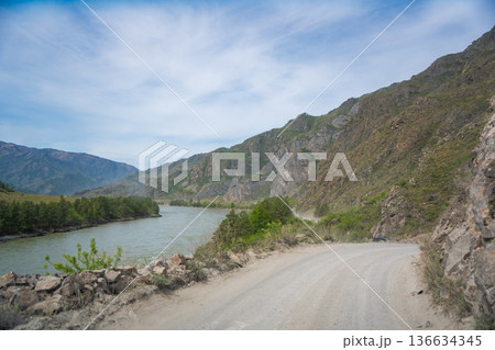 Mountain road running along the Katun river in Altai Russia. Scenic route winding through natural landscapes of the Altai mountains. 136634345
