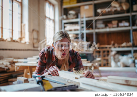 Female carpenter working on her product in carpentry workshop. 136634834