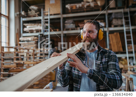 Carpenter preparing the wood pieces before making the furniture. Carpenter preparing the wood pieces before making the furniture. 136634840