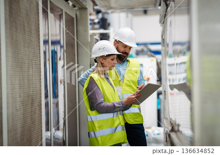 Industrial team analyzing data in high tech manufacturing plant. 136634852