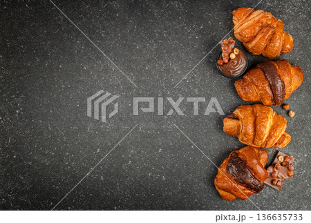 Chocolate croissants arrangement on dark stone background banner 136635733