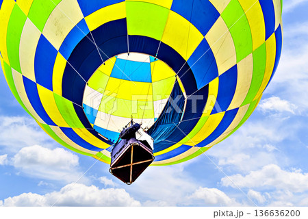 Colorful hot air balloon flying over blue sky with white clouds Colorful hot air balloon flying over blue sky with white clouds 136636200