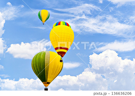 Colorful hot air balloon flying over blue sky with white clouds Colorful hot air balloon flying over blue sky with white clouds 136636206