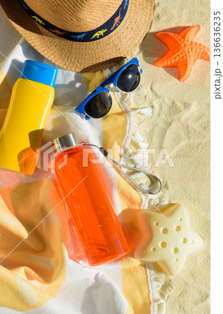 Beach Essentials with Hat, Sunglasses, Sunscreen, Kid Mold and Water Bottle. Summer Vacation Flatlay Beach Essentials with Hat, Sunglasses, Sunscreen, Kid Mold and Water Bottle. Summer Vacation Flatlay 136636235