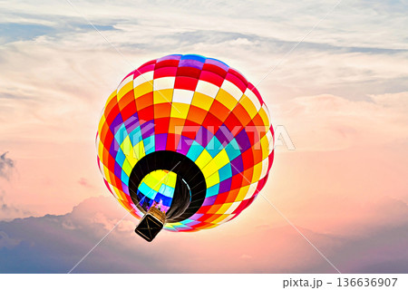 Colorful hot air balloon flying under orange sunset sky Colorful hot air balloon flying under orange sunset sky 136636907