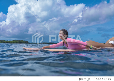 Woman Balances On Ocean Surf, Serene Scene Of Woman Paddling Woman Balances On Ocean Surf, Serene Scene Of Woman Paddling 136637255