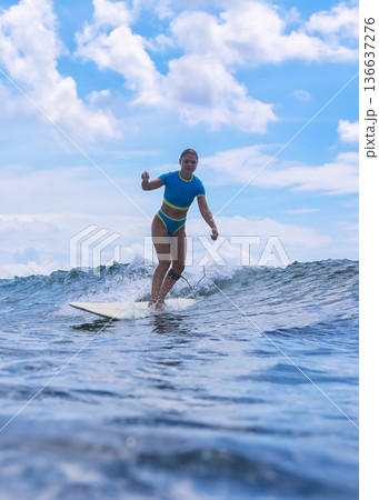 Energetic Female Surfer Demonstrates Control In Dynamic Summer Training Session 136637276
