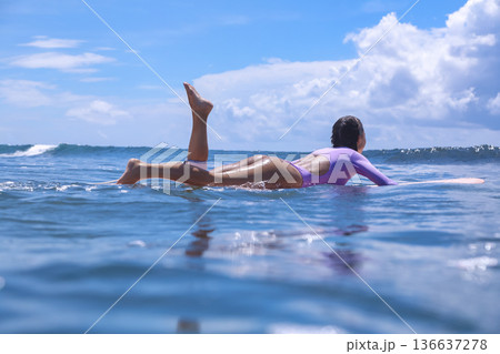 Woman Sitting On Surfboard Amid Breaking Wave Playful Beach Session 136637278