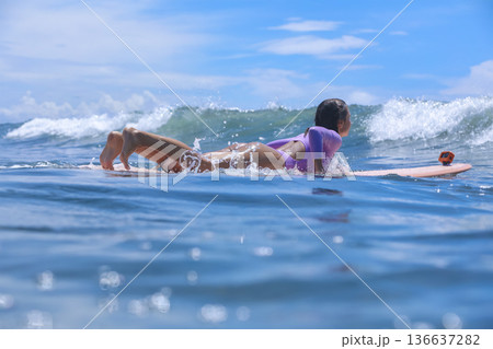 Woman Sitting On Surfboard Amid Breaking Wave Playful Beach Session 136637282
