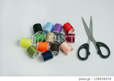 Colorful sewing thread spools with scissors on white background. Tailoring, DIY craft and handmade concept. Studio shot with copy space, high resolution detail 136638078