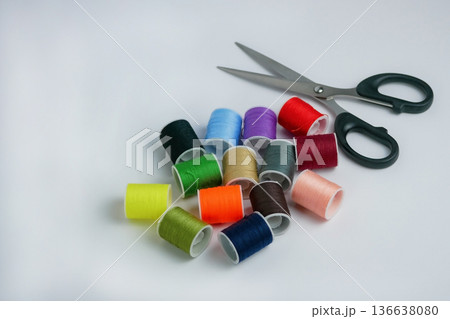 Colorful sewing thread spools with scissors on white background. Tailoring, DIY craft and handmade concept. Studio shot with copy space, high resolution detail 136638080