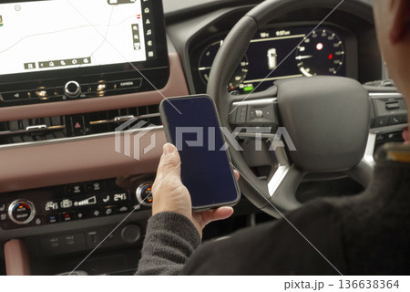 運転席でスマホを操作している男性の手元 運転席でスマホを操作している男性の手元 136638364