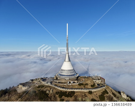 Skyward Tower Over Clouds, Aerial Shot Showcasing Mountain Communication Tower Amongst Foggy Peaks Skyward Tower Over Clouds, Aerial Shot Showcasing Mountain Communication Tower Amongst Foggy Peaks 136638489