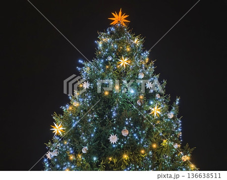 Urban Holiday Display Featuring Luminous Evergreen Adorned With Ornaments And Glowing Star 136638511