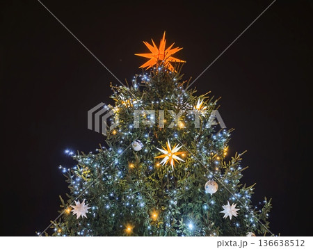 Refined Evergreen Adorned With Radiant Star And Cool White Lighting For Evening Celebration 136638512