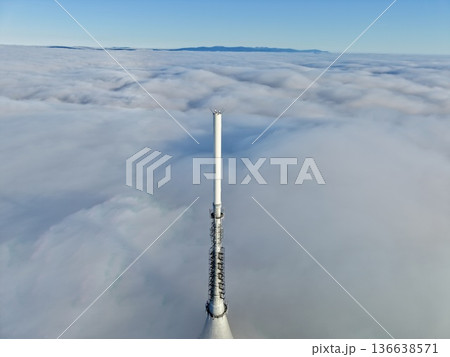 Tower Emerges Through Clouds, Minimalist Tower Standing Resiliently Amid Thick Clouds And Mist 136638571