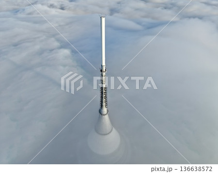 Communication Tower Glows, Rural Broadcasting Station Surrounded By Fog With Distant Mountain Backdrop Communication Tower Glows, Rural Broadcasting Station Surrounded By Fog With Distant Mountain Backdrop 136638572