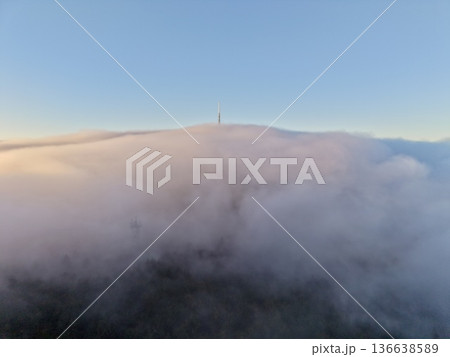 Skyhigh Communication Tower Stands Out Against Thick Cloud Cover Over Wooded Summit At Dawn Skyhigh Communication Tower Stands Out Against Thick Cloud Cover Over Wooded Summit At Dawn 136638589