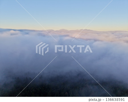 Serene Aerial Depiction Of Foggy Mountain Crest With Expansive Horizon And Calming Atmosphere Serene Aerial Depiction Of Foggy Mountain Crest With Expansive Horizon And Calming Atmosphere 136638591