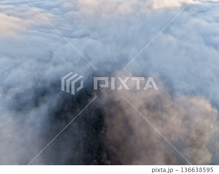 Rugged Mountain Peaks Cut Through Thick Early Morning Fog Revealing Mysterious Wooded Valleys Underneath 136638595