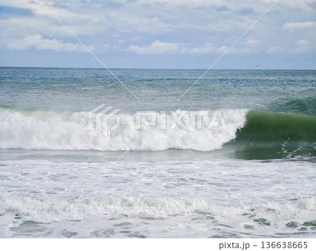 Waves Collide With Sandy Shoreline, Rough Ocean Surf Crashes Onto Deserted Coastlines Creating Dynamic Sprays 136638665