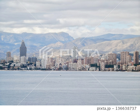 Tranquil Harbor With Distant Mountains, Peaceful Waterfront Scene With Urban And Mountain Backdrop Tranquil Harbor With Distant Mountains, Peaceful Waterfront Scene With Urban And Mountain Backdrop 136638737