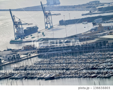 Large Port With Active Machinery, Seaside Loading Zone With Giant Cranes And Shipping Barges 136638803