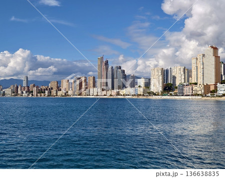 Radiant Urban Horizon Rises Above Lively Coastal Waters With Sparkling Reflections And Dramatic Clouds 136638835