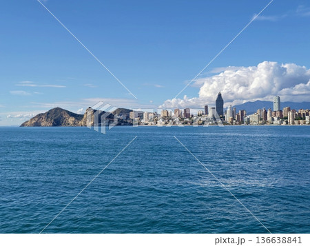 Expansive Sea Extends Toward Distant Urban Silhouette With Gentle Waves And Tranquil Atmosphere 136638841