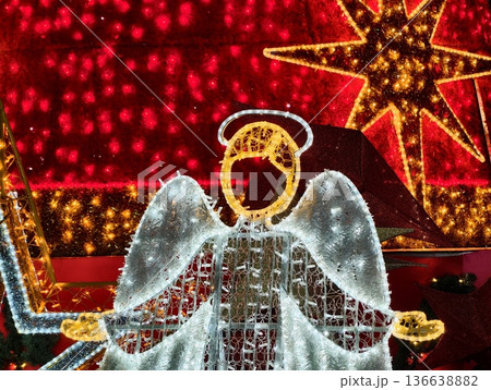 Radiant Angelic Figure Illuminated By Decorative Lights Amidst Seasonal Market Scene With Star Accents 136638882