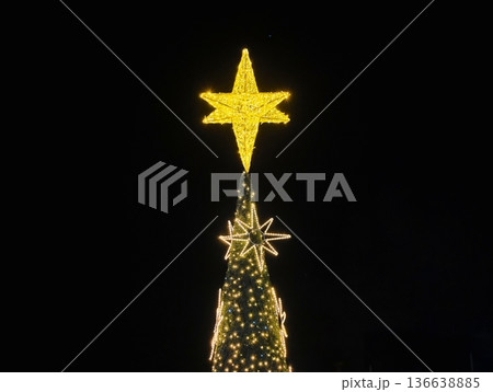 Illuminated Crown On Holiday Pine, Night Scene Showcasing Glowing Star On Decorated Evergreen Tree Illuminated Crown On Holiday Pine, Night Scene Showcasing Glowing Star On Decorated Evergreen Tree 136638885
