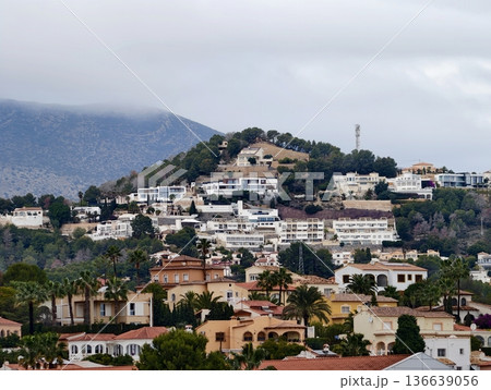 White Stucco Homes Amidst Palms, Serene Hillside Community Featuring Winding Streets And Tiled Balconies 136639056