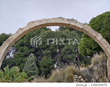 Ancient Gate Scene, Peaceful Historical Site Featuring Worn Stone Arch And Dense Leafy Surroundings Ancient Gate Scene, Peaceful Historical Site Featuring Worn Stone Arch And Dense Leafy Surroundings 136639076