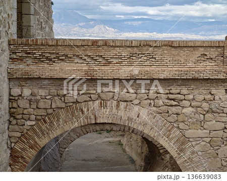 Gateway Opens To Scenic Mountains, Ancient Stone Archway Crowns Distant Mountain Ranges And Moody Skies 136639083