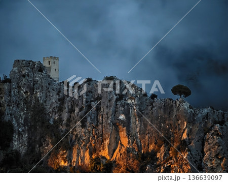 Mysterious Twilight Mountain Landscape, Sunset Over Ancient Castle With Glowing Rocks And Storm Clouds 136639097